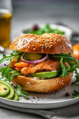 Bagel with sesame seeds with salmon avocado and arugula. Balanced diet whole food nutrition concept