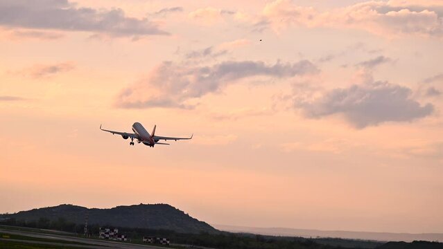 Huge airplane jet take off from airport landing zone at beautiful sunset clouds sky. 4k super slow motion raw video 120 fps
