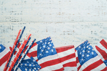 4th of July background. US flag paper napkin and picnic cocktail straws on old white table...