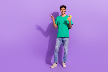 Full body photo of young man blog wear trendy clothes pointing finger empty space phone website...
