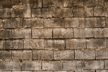 Texture of grey bricks wall with signs of concrete and mildew.