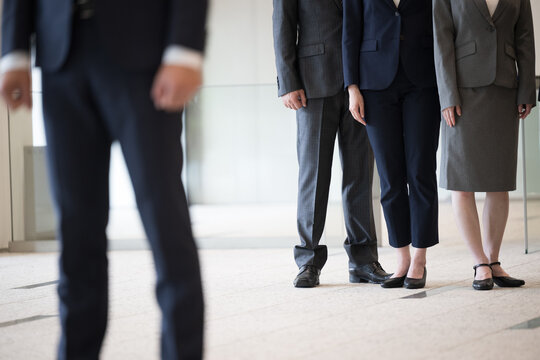 Image of promotion and jealousy within the company The feet of a businessman's suit no-face