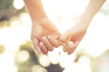 Couple lovers romantic holding hands towards with bright sun flare in public parks, or close up...