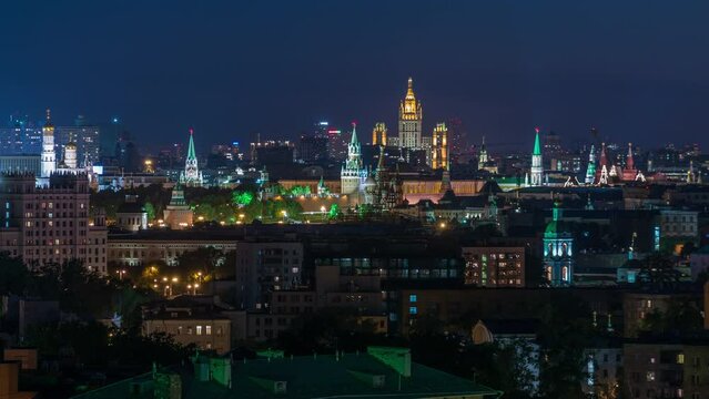 Panoramic aerial view of Moscow timelapse - Kremlin towers, State general store, Stalin skyscraper, residential buildings at night. Illuminated city from rooftop.