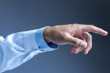 Man's hand wearing lab coat pointing index finger on grey background. Side view.