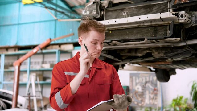 Man mechanic, holding car checkbook checking condition problematic car come repair, check overview all cars that are parked even though it just come in for repairs before sending it back customer.