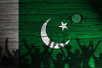 Pakistan flag painting on wood and peoples shadow