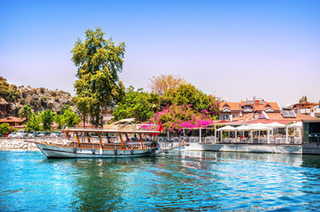 Fototapeta na wymiar Pleasure boats on the river and a restaurant, Dalyan River, Lycian Tombs, Mediterranean Sea, Marmaris, Turkey
