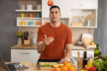 A homely and healthy male prepares nutritious diet, including variety of fruits. Following cooking...
