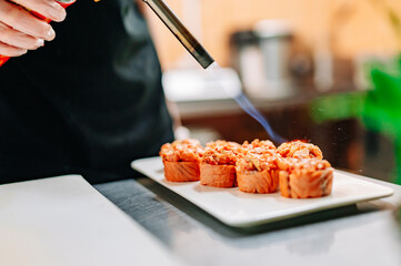 professional chef's hands making sushi roll in a restaurant kitchen