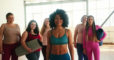 African American woman stands with friends in light gym