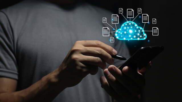 man hand with pen pointing at digital white cloud hologram with various icons on dark background. Cloud computing and storage server concept.