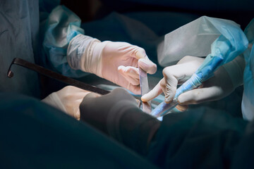 surgeon works in the operating room by the light of a lamp