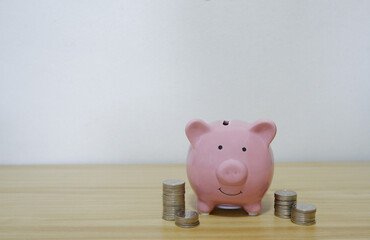 coin and piggy pink on the wood table savings economy concept