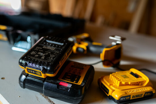 Miercurea Ciuc, Romania- May 23 2023: Charging Dewalt lithium-ion battery in a small woodworking shop.