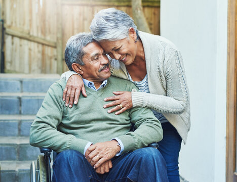 Support, wheelchair and senior couple hug with care, smile and love by elderly happy people in retirement. Old man, rehabilitation and person with disability and woman helping in empathy in marriage