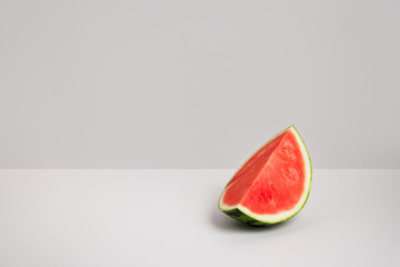 Big slice of watermelon on light grey background. Fresh red summer fruit. Healthy diet with delicious berry and vitamins. Copy space, front view. Clean eating, detox concept.