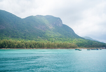 Ben Dam Port in Con Dao island, Vietnam with beautiful blue sea blue sky mountain and colorful boats.