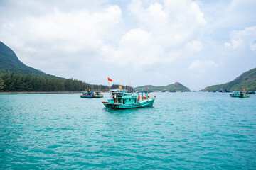 Ben Dam Port in Con Dao island, Vietnam with beautiful blue sea blue sky mountain and colorful boats.