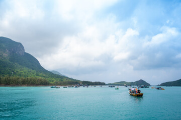Ben Dam Port in Con Dao island, Vietnam with beautiful blue sea blue sky mountain and colorful boats.