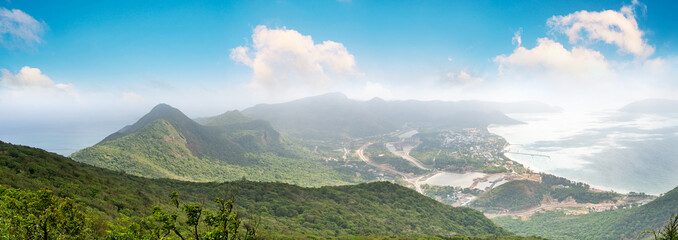 a peaceful Con Dao island, Vietnam, view from Thanh Gia mountain. Coastal view with waves, coastline, clear sky and road, blue sea and mountain.