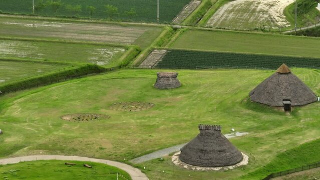 Aerial view of thatched roof huts in historic Jomon village recreation