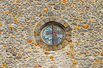 Fototapeta na wymiar Oculus on the facade of the church of Saint Genevieve in the small village of Montigny Lencoup in the French department of Seine et Marne in the capital region of Ile de France near Paris
