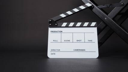 Fototapeta na wymiar Clapperboard or clap board or movie slate with director chair use in video production ,film, cinema industry on black background.