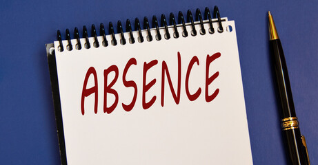 ABSENCE - word in a white notebook on a blue background with a pen