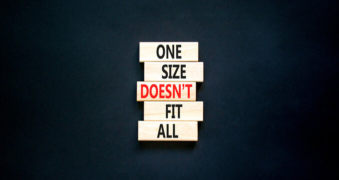 One size does not fit all symbol. Concept words One size does not fit all on wooden blocks. Beautiful black table black background. One size does not fit all business concept. Copy space.
