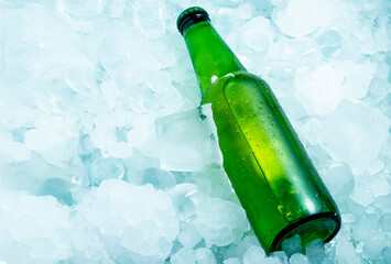 Bottle of green beer in very cold ice cubes horizontal