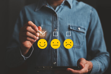 concept of customer service evaluation or satisfaction, customer doing a satisfaction assessment Using the tick pen, select smiley face emoticon. show satisfaction with the service, virtual screen.