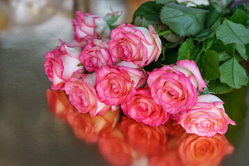 Bouquet of beautiful red roses close-up on a silver background with reflection