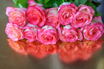 Bouquet of beautiful red roses close-up on a silver background with reflection