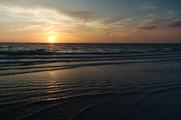 Sunset dark at Florida beach. Calm water with yellow sky from sun. 