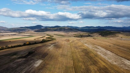 Aerial distant view of Balkan mountain range ( Also known as Stara planina ) and agricultural field.