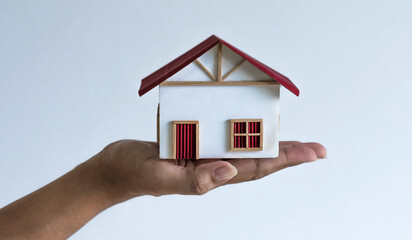 Fototapeta na wymiar Hand holding house model on white background, loan and real estate concept