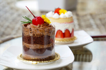 Selective focus on chocolate chiffon and blurred at strawberry chiffon flavorful cake Decorate the cake with whipped cream and cherries. and stories that are cute and appetizing