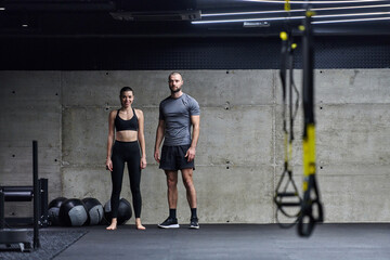 Muscular man and fit woman in a conversation before commencing their training session in a modern...