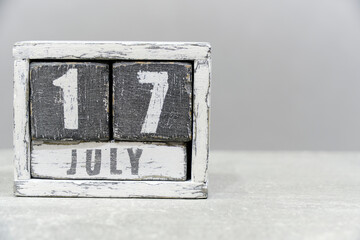 Calendar for July 17, made of wooden cubes, on gray background.With an empty space for your...