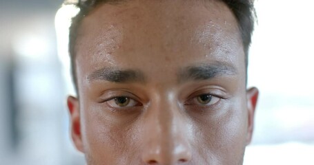 Close up portrait of happy biracial businessman smiling at office, in slow motion