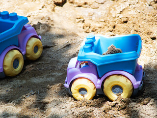Children's toys - dump truck on the beach sand
