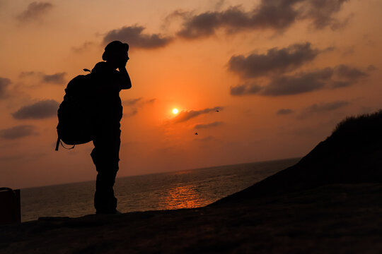 the silhouette image of an young traveler standing near horizon