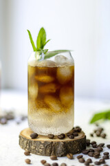 Cold summer cocktail with black coffee tonic mint and ice in glass on white background