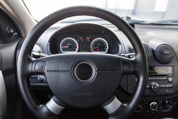 Interior view with steeering wheel and dashboard of luxury very expensive new white car stands in the washing box after detailing in vehicle repair workshop