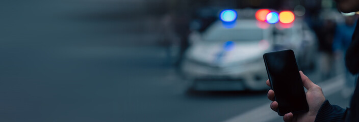 Holding a phone in front of police cars