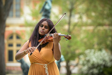Lovely black woman playing violin in a park