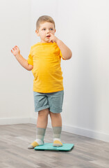 overweight little boy on scales at home