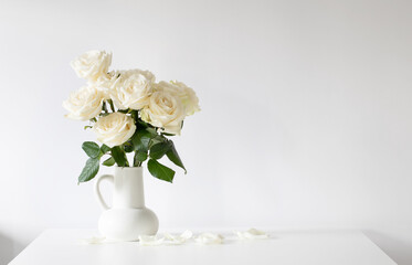 bouquet of white roses in jug on white background