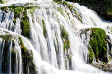 Close up view to water stream in the fast waterfall. Blurred motion water flow